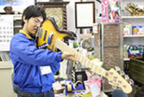 ギターを手に取るスタッフ